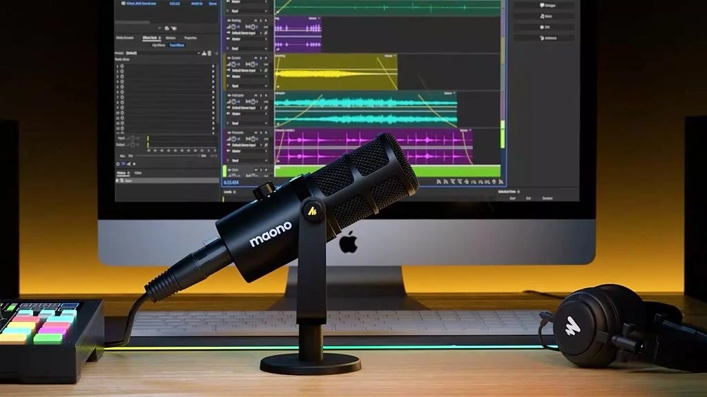 桌面上的Maono麥克風和聲卡，背景是電腦屏幕顯示音頻編輯軟件。